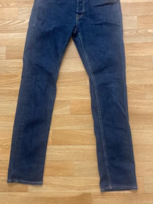 Mörkblå raka jeans - Säljer ett par mörkblå jeans med rak passform och klassiska kontrastsömmar. Jeansen har fem fickor och normal midja. Perfekta för en avslappnad och stilren look.