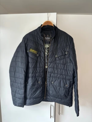 Jättefin Barbour dun jacka M - Jättefin snygg och trendig marinblå barbour jacka dunjacka i storlek M säljes. Väldigt fint skick och grym passform perfekt nu till hösten. Inga som helst defekter och tveka inte vid minsta fråga eller funderingar!