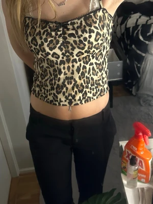 Leopardmönstrad croppad linnetopp - Snygg croppad linnetopp med leopardmönster och tunna axelband. Toppen har en lätt rynkad detalj framtill och är perfekt för dig som vill sticka ut. Passar till både jeans och kjol för en trendig look.