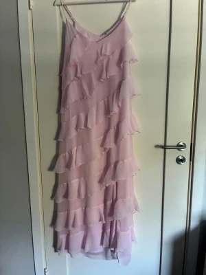 Ljusrosa långklänning med volanger - Supersöt ljusrosa långklänning från Vero Moda. Pris kan diskuteras 