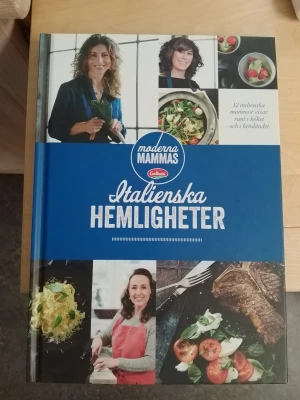 Moderna Mammas Italienska Hemligheter - Kokbok med hårda pärmar där 12 italienska mammor delar sina bästa recept och berättelser från Italien. Boken innehåller 48 recept och många färgbilder på mat och personer. Perfekt för dig som vill upptäcka italiensk matlagning och kultur.