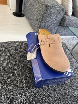 Beige Birkenstock tofflor - ✅ Säljer mina Birkenstock Boston. Fick dem i present, men de passar tyvärr inte mig. Skorna är i fint skick och har endast provats/använts sparsamt.  ✅ Kvitto finns såklart !  ✅ Snabb och smidig affär. ✅ Hör gärna av dig vid frågor eller om du vill ha fler bilder!  Tyvärr inga returer då kvitto och all information finns tillgänglig innan köp. 😊