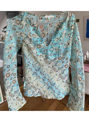 Y2k Boho-blus!☀️ - Säljer en tunn, långärmad blus med v-ringning och bohemiskt mönster i turkos, beige och brunt. Blusen har lätt transparent material och figurnära passform med lätt utsvängda ärmar. Perfekt för dig som gillar färg och mönster!Supersnygg nu till sommaren!!❤️
