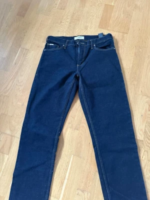 Mörkblå jeans från Lindbergh  - Snygga mörkblå jeans från Lindbergh. Modellen är loose fit romeo och storleken är 32/32. Jeansen är helt oanvända.
