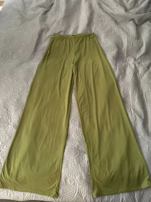 Gröna vida byxor från Zara  - Snygga gröna byxor från Zara med breda ben och elastisk midja. Byxorna har en avslappnad passform och är perfekta för en chill och trendig look.