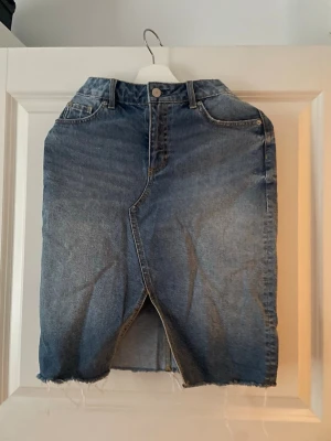 Blå jeanskjol  - Säljer en blå jeanskjol i klassisk modell. Midikjol.