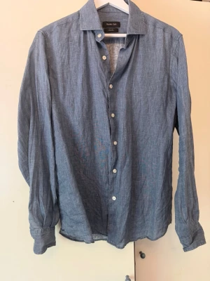 Blå linneskjorta. Massimo dutti - Linne skjorta från massimo dutti. Skjortan är använd 2-3 gånger och säljer p.g.a fel storlek. Storlek S.