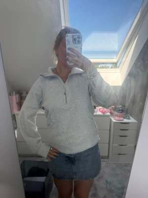 Lululemon halv zip hoodie - Säljer en ljusgrå hoodie från lululemon med halv dragkedja framtill och stor känguruficka. Hoodien har en hög krage och ribbade muddar vid ärmslut och nederkant. Storlek xs/s. Super bra skick. 