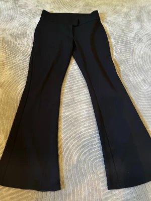 Svarta bootcut leggings - Säljer ett par svarta leggings med bootcut-modell och hög midja. De har en slät och stretchig kvalitet som sitter bekvämt och low.