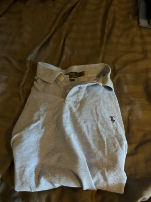 Ljusblå Ralph lauren piké - Tja! Säljer en av mina fina Ralph lauren pikéer🙌 viktigt att tänka på är att den är storlek L men passar S-M funkar på mig som är 183 och du kan även va kortare🤞✌️hör av dig vid någon fundering🙌