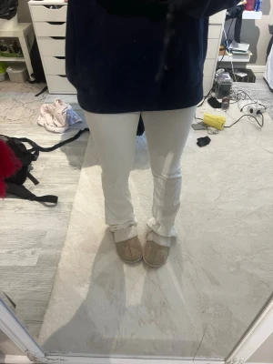 Vita bootcut jeans - Säljer ett par vita bootcut jeans med låg midja och klassiska fickor både fram och bak. Jeansen har en snygg utsvängd passform och är perfekta för dig som vill ha en clean och fräsch look. Materialet känns mjukt för extra komfort.