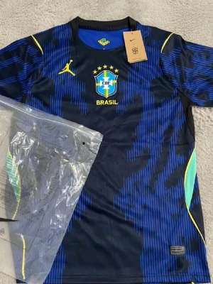 Blå Brasilien Nike fotbollströja - Snygg blå Brasilien fotbollströja från Nike med gula detaljer och CBF-emblem på bröstet. Tröjan har korta ärmar, rund hals och ett mönster i olika blå toner. Perfekt för dig som älskar fotboll och vill sticka ut på planen. Helt ny och oanvänd!