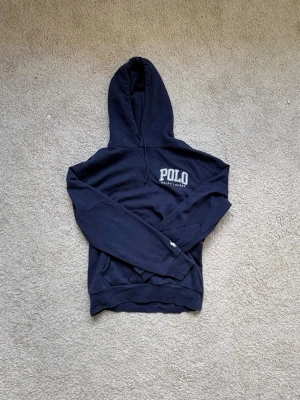 Ralph Lauren hoodie  - Mörkblå hoodie från Ralph lauren, köpt på Ralph laurens egna hemsida. Använt sparsamt sedan den köptes i julas. Storlek M. Kan leta fram kvittot ifall man känner sig osäker :) Nypris ungefär 1200 :- Längd: 58 cm Bröst till bröst: 52 cm Ärm: 45 cm