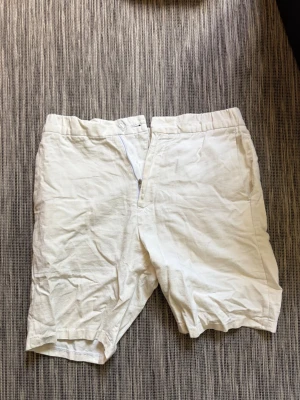Vita linneshorts från Riley  - Säljer ett par vita shorts från Riley i skönt linne. De har elastisk midja baktill, fickor i sidorna och klassisk passform. Perfekta för varma dagar och ger en clean och fräsch look. Storlek 46, sitter som S. Dom ser skrynkligare ut än vad de är för att jag inte använt dom på länge.  Hör av dig vid frågor// kan gå ner i pris vid snabb affär!😃/ Milton