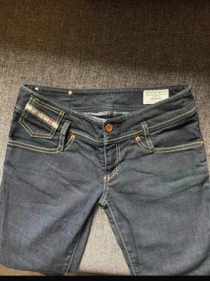 Mörkblå jeans från Diesel - Snygga mörkblå jeans från Diesel. Jeansen har låg midja,  Perfekta för dig som gillar en stilren och modern look.