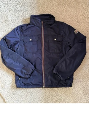 Moncler - Snygg mörkblå vintage vindjacka från Moncler med huva som går att ta bort (har inte med den i bilden) Köpt från fashion store och är självklart äkta 