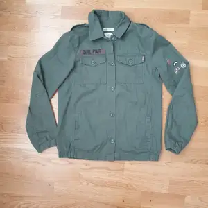 Militärgrön jacka från H&M stl 164 med tryck på ärm och baksida. 