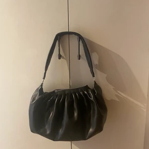 Svart axelväska  - Svart rymlig axelväska från Gina Tricot. Den har ett innerfack med dragkedja. Säljer då den aldrig har kommit till användning. Skickar endast och köparen står för frakten (spårbart). 🖤