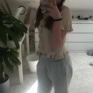 En fin stickad tröja från SHEIN  - Den är beige och ribbad, volanger vid ärmar. 