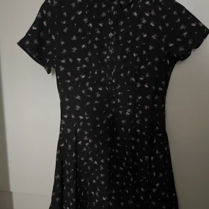 Missguided Klänning - Klänning från Missguided med floral pattern och knappar. Snygg skjortkrage. Använd en gång. 