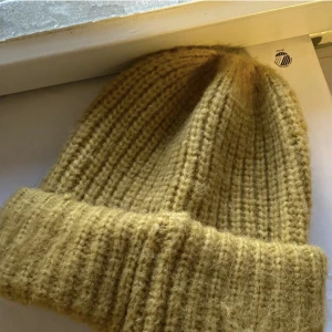 Mössa - Gul mössa i one size, köpt på Glitter. Helt oanvänd. Frakt tillkommer!