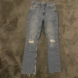Zara jeans - Blåa jeans från Zara med hål i knäna.