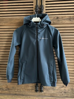 Sail Racing JR Bowman softshell hood s. 160 - Säljer en superfin JR Bowman softshell hood från Sail Racing i storlek. 160. Knappt använd så i nyskick. Färg marinblå.