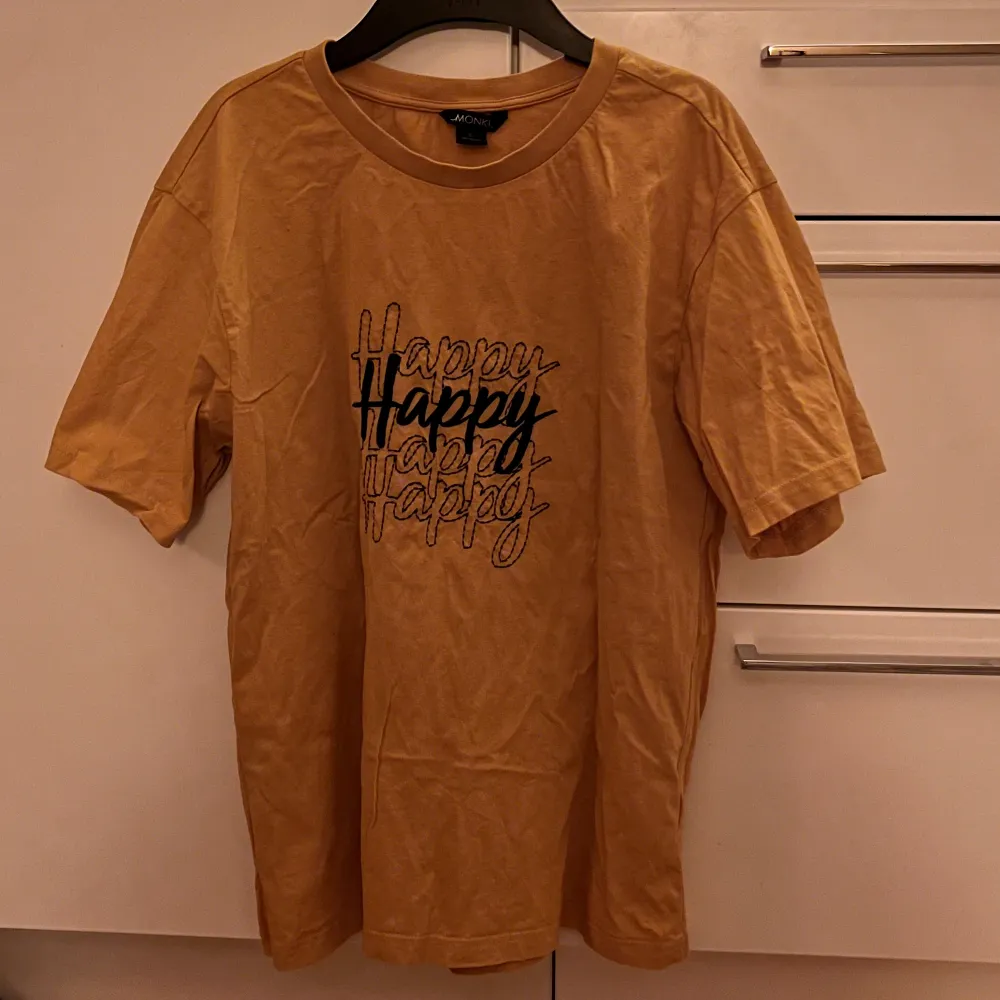 Senapsgul t-shirt med tryck från Monki. Storlek S, bra skick. (ursäkta för dåligt ljus på bilden, men den är senapsgul egentligen). T-shirts.