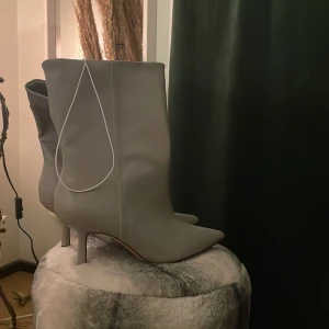 Gråa snygga boots med klack - Sjukt snygga gråa ”boots”, som är låga i modellen. Helt oanvända pga fel storlek. Väldigt fint skick och prislapp sitter kvar. Budgivning vid större intresse.