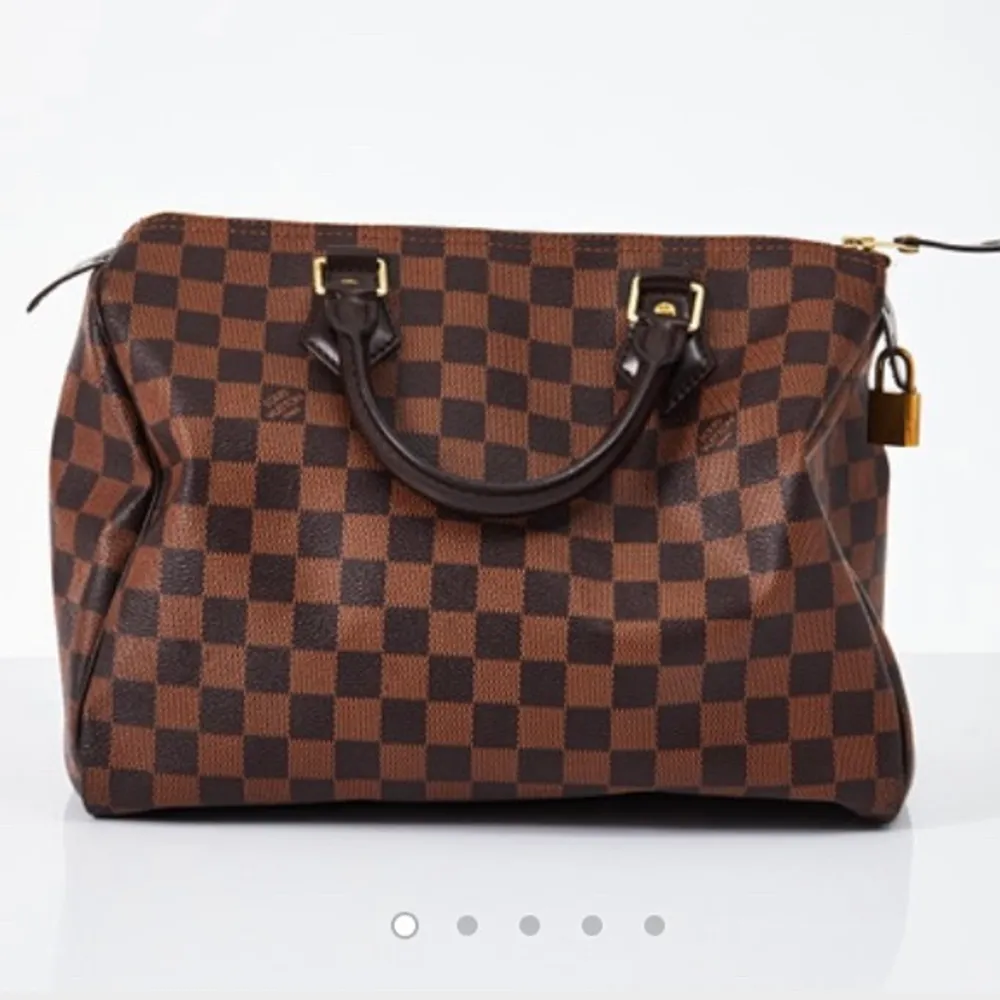 TRYCK EJ PÅ KÖP NU. Budgivning pågår här: https://auctionet.com/2591248-louis-vuitton-speedy-30-handvaska-monstrad-damier-ebene-canvas-med-morkbruna-skinndetaljer-fodrad-med-rod-textil-ett-mindre-fack-invandigt-tillhorande-las-markt-med-datumkod-frankrike. Väskor.