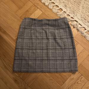 En grå mänstrad kjol i strl S från H&M divided. Knappt använd så den är i nyskick!
