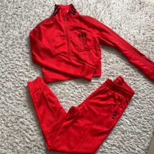 Röd tracksuit. Adidas x Alexander Wang - Röd tracksuit i storlek XS. Nyskick då den endast är använd en gång. Tight passform.   Nypris var cirka 4000 kronor, säljer båda delarna för 1000 kronor inklusive frakt.