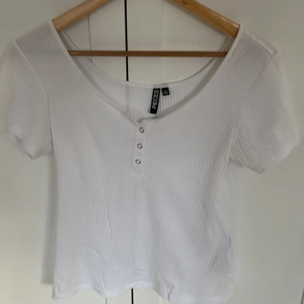 Supersöt vit t-shirt med knäppning, den är i storlek L men är som en M❣️. Toppar.