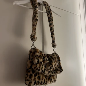 Leopardväska - Snygg y2k axelremsväska med leopardtryck. Den är fluffig och har mycket utrymme. Jag kan mötas upp i Stockholm eller posta❣️