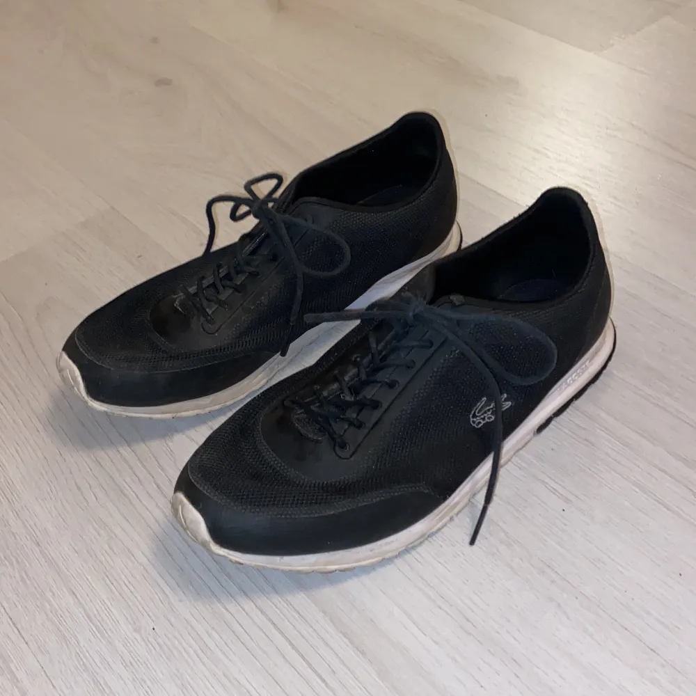 Använda svarta Lacoste skor med vit sula. Storlek 39. Köpta för 1000kr. . Skor.