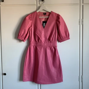 Rosa klänning - Bubbelgumsrosa skinn klänning från Vero Moda i storlek XS. Oanvänd på prislappen kvar. 