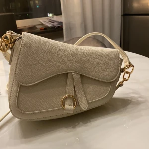 Helt oanvänd axelbandsväska - Fin beige axelremsväska som aldrig används