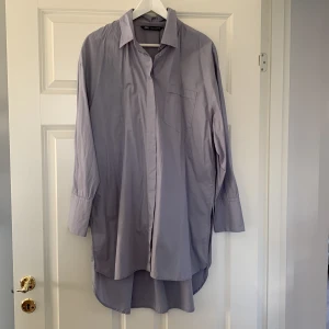 Långskjorta  - Gråblå långskjorta med slitsar på sidorna. Längre baktill snygg med tights eller klänning sommar 