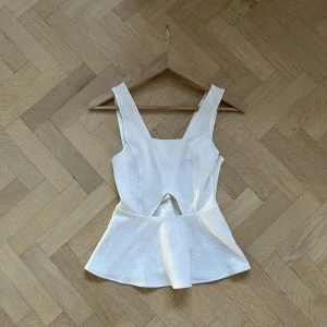 vit topp - Topp med volang nedtill eller peplum topp. Jättesöt! Väldigt stretchig men har också en dragkedja på sidan. Bra skick! 