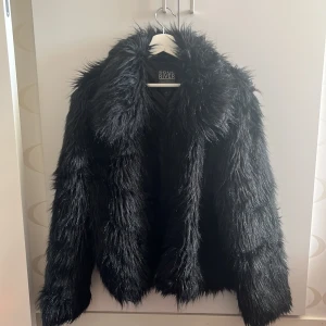 Svart fakepälsjacka - Svart pälsjacka i fakepäls. Använd ca. 2 gånger. Fäller lite hår. 