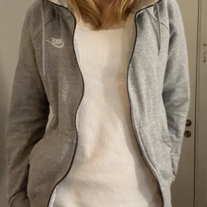 Nike zipup - Säljer den för att den inte kommer till användning längre. Har inte använt den sen vintras. Den har dock tappat två svarta saker som skulle sitta på snörena