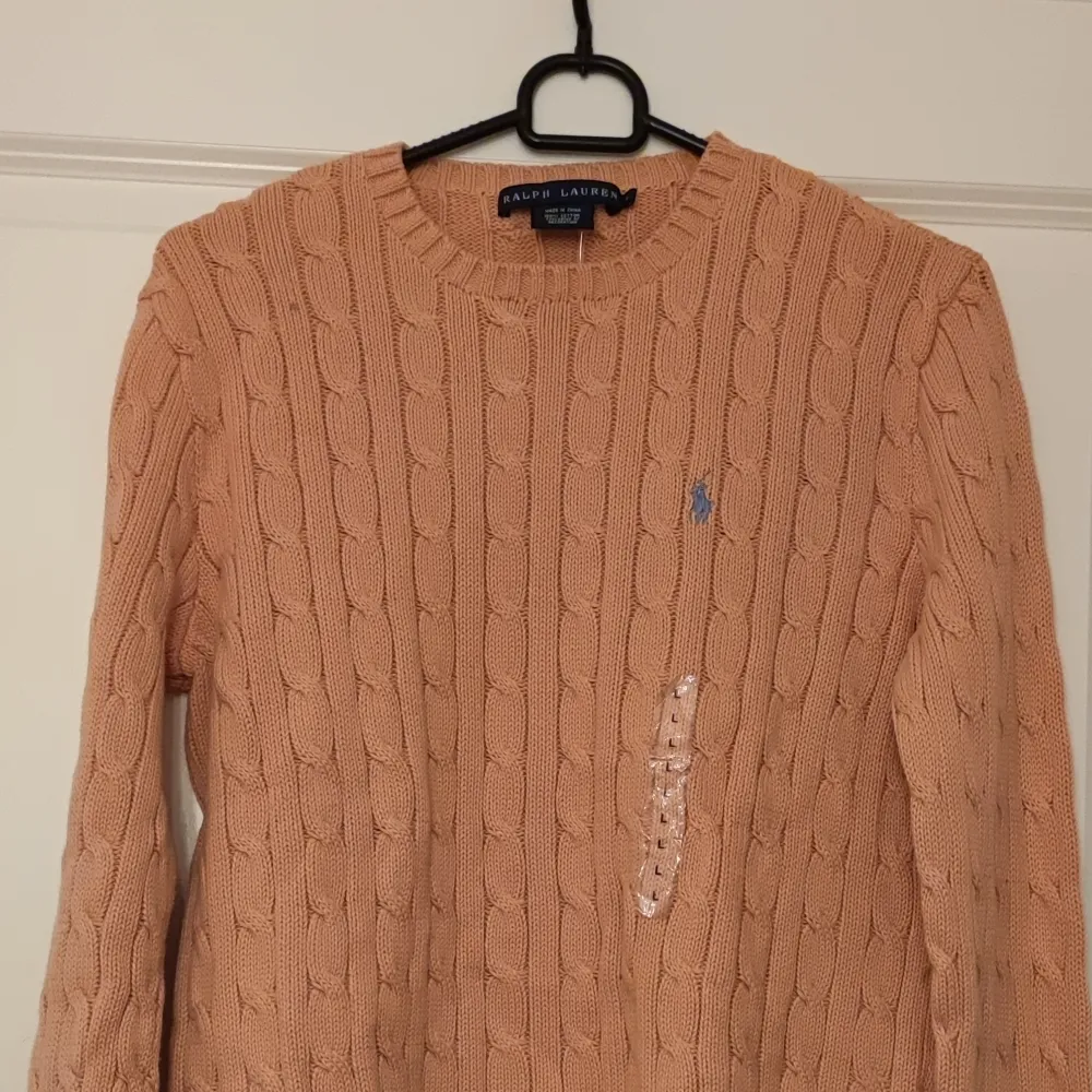 Hej! Köpte denna fina kabelstickade tröjan i Usa i Ralph Lauren butiken. Det var dock fel storlek för oss. 100% Orginal. Helt ny,  aldrig använd.  Orange färg med Grön logga. . Stickat.