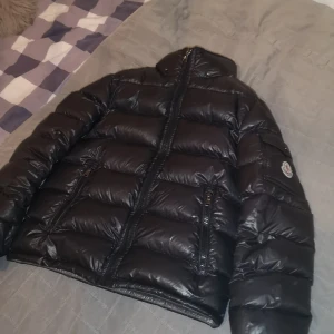 Moncler jacka strorlek 12år/152cm - Säljet min fina moncler jacka luvan är bort tappad men man kan sätta på en annan luva från valfri annan jacka:) 