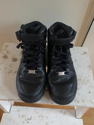 Nike Airforce mid  - Ett par svarta Nike, inte använda men det är en liten bit av flärpen på carborren som är borta på ena sidan, inget man märker av. Annars topp skick 😊 Strl 38