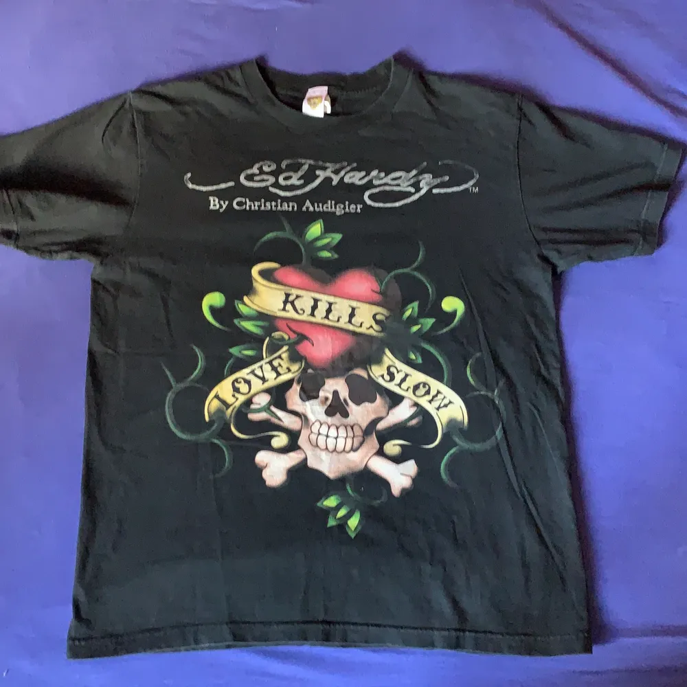 Ed Hardy t-shirt med love kills slow tryck och tryck på ryggen, är en L men är ganska liten i storlek. T-shirts.