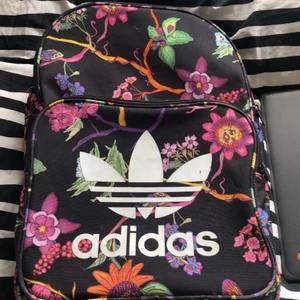 Adidas Ryggsäck - Säljer nu min snygga adidas ryggsäck som köptes i december 2019. Säljer den eftersom 1. den är inte min stil längre 2. den används inte. I bild två ser ni den jämfört med min skoldator, så ryggsäcken är rätt stor. 