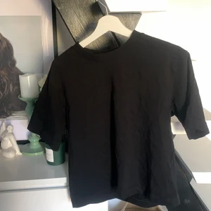 Svart T-shirt  - Vanlig svart T-shirt med lite längre armar från Gina tricot. 