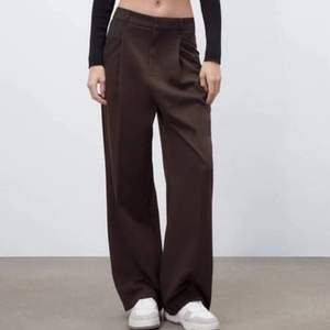 Full length never worn Zara Trousers In Brown. High waist trousers, zip fly and top button fastening.   Size M (about 98CM) Style: Wide Leg Fabric: polyester, viscose, elastane Original Price: 799sek