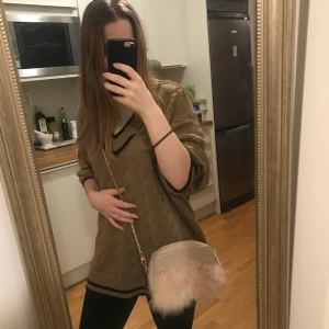 Ljusrosa axelväska med fjädrar - En liten ljusrosa axelväska med äkta fjädrar på framsidan samt gulddetaljer, guldig avtagbar kedja samt ett innerfack. Väskan är köpt i Spanien och kommer från Parfois och var en present jag fick för drygt 5 år sedan. Tyvärr blev den aldrig använd men förhoppningsvis kan någon annan få glädjas åt den:)