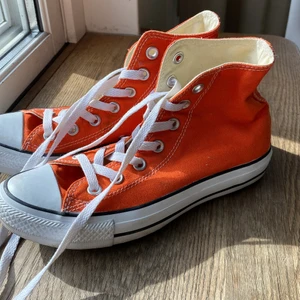 Orange converse  - Fina converse i härlig orange färg, jättesnygga till sommaren. De är i storlek 37 och i riktigt bra skick; rena skosnören, inget utsuddat märke och hyfsat ren sula. De enda defekterna jag kan se är lite smuts som visas på bild 3, går troligtvis bort i tvätt. Budgivning om många är intresserade. Köparen står för frakten🚚💕
